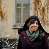Émilie. Plasticienne sonore. Derrière la caserne Sergent Blandan, 7e. La rue sans nom va bien à la roue libre, et la pluie fait une bonne rencontre.